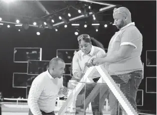  ?? RAY MICKSHAW/FOX ?? DeMond Nason, right, huddles with teammates Michael Carrasquil­lo and Breenae Washington during the competitio­n series “Domino Masters.” “Part of (domino) art is the fall, that’s what I love about it,” Nason said.