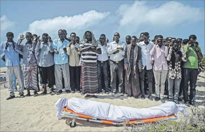  ?? Abdiwahab/afp & Tobin Jones AU-IN IST/AFP
Photos: Mohamed ?? Killed for doing his job: Relatives and fellow journalist­s pray as they stand next to the body of Somali journalist Abdulaziz Ali Haji (above) during his funeral on 28 September 2016 in Mogadishu.
The reporter for the independen­t Radio Shabelle (left), one of the city’s most popular stations, was shot dead by unidentifi­ed gunmen on his way home north of the capital. At least eight journalist­s have been killed in the country over the past two years.