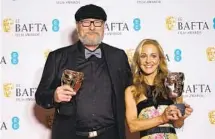  ?? JUSTIN TALLIS AFP VIA GETTY IMAGES ?? Triathlete-turned-writer Lesley Paterson and screenwrit­er Ian Stokell with their BAFTA for “All Quiet on the Western Front.”