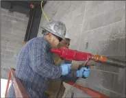  ?? (NWA Democrat-Gazette/Charlie Kaijo) ?? Francisco Gonzalez (front) and Biem Lome drill a hole Thursday for a gas line to a kitchen stove and water heater at Springdale’s Fire Department new Station No. 8.