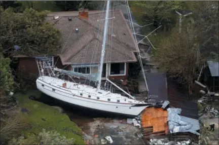  ?? STEVE HELBER — THE ASSOCIATED PRESS ?? A sailboat is shoved up against a house and a collapsed garage Saturday after heavy wind and rain from Florence, now a tropical storm, blew through New Bern, N.C.