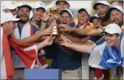  ?? ALESSANDRA TARANTINO ?? The Europe team led by captain Luke Donald, center, lift the Ryder Cup after beating the U.S. team, 16 1/2-11 1/2.
