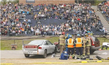  ?? STAFF PHOTOS BY C.B. SCHMELTER ?? Students watch from the bleachers as first responders work the scene of a simulated crash at Robert Talaska Field on the campus of Soddy-Daisy High School on Wednesday.