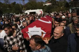  ?? KHALIL HAMRA — THE ASSOCIATED PRESS ?? Turkey's Interior Minister Suleyman Soylu, right, helps with a coffin for one of the miners killed in a coal mine explosion during his funeral in Amasra in the Black Sea coastal province of Bartin, Turkey, on Saturday.