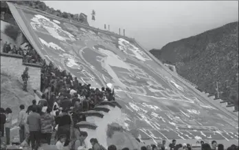  ??  ?? Tourists and pilgrims admire a giant thangka work at Drepung Monastery in Lhasa, Tibet autonomous region in September.