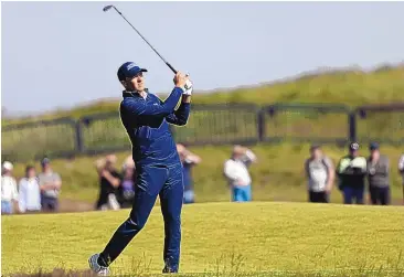  ?? IAN WALTON/ASSOCIATED PRESS ?? Jordan Spieth hits off the first fairway during the first round of the British Open on Thursday. He shot a 5-under 65 at Royal St. George’s and is tied for second.