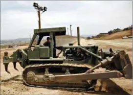  ?? DENIS POROY — THE ASSOCIATED PRESS FILE ?? A California Army National Guardsman grades dirt with a tractor next to the second U.S.-Mexico border fence in San Diego. President Donald Trump said he wants to use the military to secure the U.S.-Mexico border until his promised border wall is built.