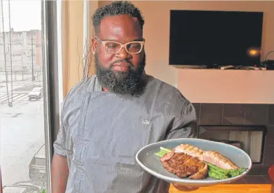  ?? LESLIE ADKINS/ FOR THE SUN- TIMES ?? Chef Lamar Moore presents a healthy meal of grilled ribeye steak, salmon and asparagus.