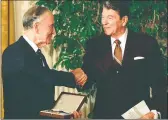  ?? Doug Mills / Associated Press ?? President Ronald Reagan shakes hands with former Ambassador to Japan Mike Mansfield, left, after giving him the Presidenti­al Medal of Freedom at a White House luncheon on Jan 19 , 1989. In what he said would the last speech he would give as president, Reagan warned: “If we ever closed the door to new Americans, our leadership in the world would soon be lost.”