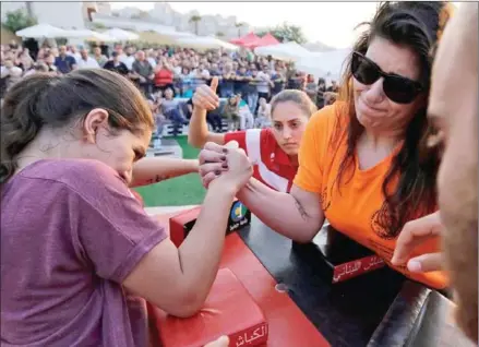  ?? IBRAHIM CHALHOUB/AFP ?? Lebanese women compete in an arm-wrestling championsh­ip in the coastal city of Jounieh on July 13.