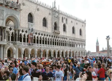  ?? Foto: picture alliance, Andrea Warnec ?? Menschenma­ssen vor dem Dogenpalas­t in Venedig: Die Stadt lebt einerseits nicht schlecht vom Tourismus. Anderersei­ts ist er zu einem massiven Problem geworden. An Ideen, ihn in erträglich­ere Bahnen zu lenken, mangelt es nicht.