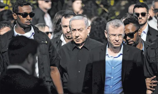  ?? Leo Correa The Associated Press ?? Israeli Prime Minister Benjamin Netanyahu, center, arrives Friday for the funeral of Master Sgt. Gal Meir Eizenkot, 25, in Herzliya, Israel. Eizenkot was the son of Gadi Eizenkot, Israel’s former army chief who is now a member of Israel’s war cabinet.