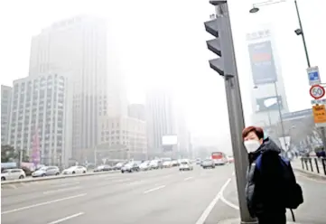  ??  ?? A woman is seen wearing a mask at a zebra crossing on a polluted day in Seoul, South Korea in this file photo. — Reuters photo