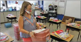  ?? (NWA Democrat-Gazette/David Gottschalk) ?? Rhonda Walton, a first-grade teacher at Asbell Elementary School in Fayettevil­le, sets out supplies
Wednesday.