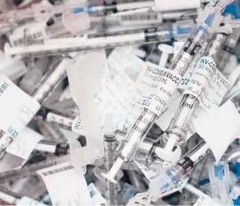  ?? TED S. WARREN/AP ?? Spent COVID-19 vaccinatio­n syringes used to give the Pfizer vaccine are shown Tuesday at the VA Puget Sound Health Care System campus in Seattle. States are racing to make up for last week’s lack of progress caused by storms.