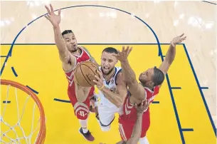  ?? AP ?? The Warriors’ Stephen Curry, centre, drives to the basket against the Rockets in Oakland.