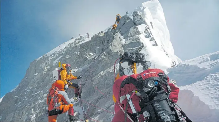  ?? AFP ?? Lugar supremo. Un grupo de montañista­s en el tramo final hacia la cumbre del Everest. Delante de ellos, el mítico “Escalón Hillary”, que ya no es parte de la gran montaña.