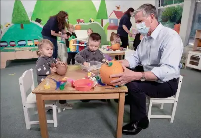  ?? The Canadian Press ?? Liberal Leader Andrew Wilkinson sits with children during a campaign stop at a childcare facility, in North Vancouver on Friday. A provincial election will be held in B.C. on October 24.