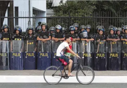  ?? —ALEXIS CORPUZ ?? TIGHTWATCH Policemen guard Gil Puyat Avenue as part of security measures around the venue of the 30th Associatio­n of Southeast Asian Nations summit at the Philippine Internatio­nal Convention Center.