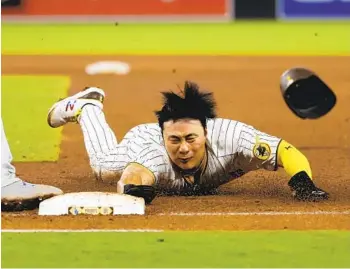  ?? K.C. ALFRED U-T ?? The Padres’ Ha-seong Kim dives back safely to first base after a fly ball by Trent Grisham on Friday night.