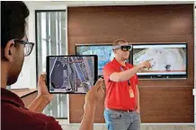  ?? [PHOTO PROVIDED] ?? Baker Hughes’ Rohit Nutalapati and Dustin Sharber use the company’s augmented reality software to collaborat­e in a virtual drilling rig environmen­t using an Apple iPad and Microsoft HoloLens mixed-reality headset.