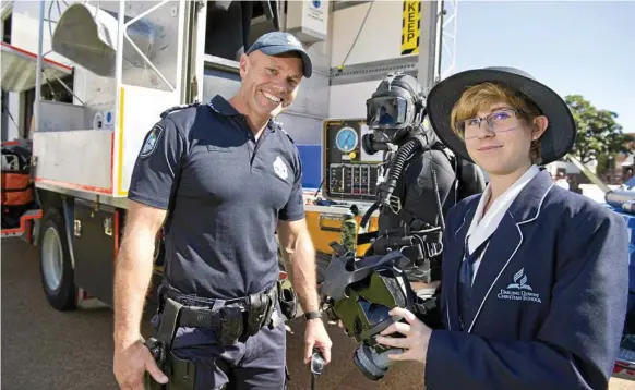  ?? Photo: Kevin Farmer ?? JOINING FORCES: Ashleigh McKie of Darling Downs Christian School learns about the dive unit from Senior Constable James Hall during Police Experience Day for school leavers.