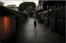  ?? JAE C. HONG — THE ASSOCIATED PRESS ?? A boy chases a bird on an empty Olvera Street in downtown Los Angeles on Dec. 15.