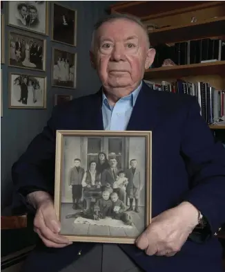  ?? TED PRITCHARD FILE PHOTO ?? Holocaust survivor Philip Riteman at his Bedford home holds a family photo taken as a child growing up in Poland in this file photo. Riteman had spent the last 25 years visiting North American schools to teach students about his experience­s as a Holocaust survivor.