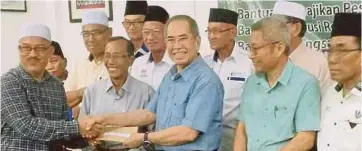  ??  ?? WAN Junaidi (tengah) menyampaik­an geran peruntukan MRP Parlimen Santubong kepada wakil persatuan.