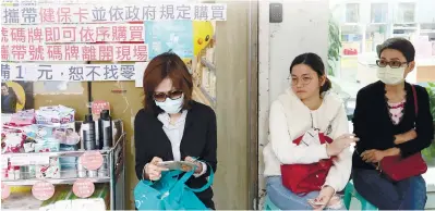  ??  ?? People wait in a line to buy face masks outside a pharmacy in Taipei, Taiwan. – REUTERSPIX