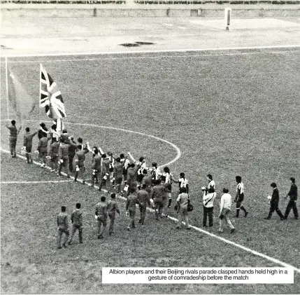  ?? ?? Albion players and their Beijing rivals parade clasped hands held high in a gesture of comradeshi­p before the match