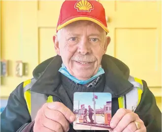  ?? TINA COMEAU ?? Ritchie Hopkins holds a photo of himself from his early days of working at the Shell gas station in Arcadia, Yarmouth County. The gas station, which has operated as D.K. Muise Motors for the past 12 years, permanentl­y closed on March 11, as the economics of keeping it open weren’t feasible anymore. Hopkins had worked there for nearly 46 years.