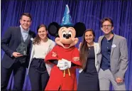  ?? / ©Disney/Gary Krueger ?? SCAD finalists Zeke Waters (left), Carolyn Teves, Remi JeffreyCok­er and Nicholas Hammond pose together with Mickey Mouse after being declared the first place winners of the Walt Disney Imagineeri­ng’s 28th Imaginatio­ns Design Competitio­n.