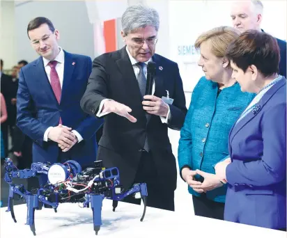  ?? (Fabian Bimmer/Reuters) ?? SIEMENS CEO Joe Kaeser shows Polish Prime Minister Beata Szydlo (right) and German Chancellor Angela Merkel a 3-D printer at the Siemens booth during a media tour yesterday at Hannover Messe, the world’s biggest industrial fair, in Hanover, Germany.