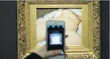  ??  ?? A visitor takes a picture of Gustave Courbet’s 1866 The Origin of the World at Musée d’Orsay in Paris.