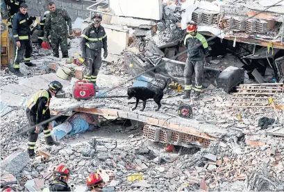  ?? GENT SHKULLAKU AFP VIA GETTY IMAGES ?? Italian rescue workers search for survivors among the rubble of Tuesday’s earthquake in the western Albania town of Thumane.