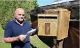  ??  ?? Bernard Colin, since 37 years guardian of the west cemetery of Charlevill­e-Mezieres where French poet Arthur Rimbaud is buried, opens a letter box dedicated to the poet in Charlevill­eMezieres. — AFP photos