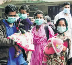  ??  ?? A FAMILY wearing protective masks at a hospital in Kozhikode on May 25.