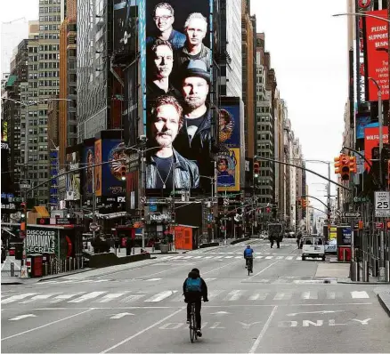  ?? Brendan Mcdermid - 31.mar.20/Reuters ?? Ciclistas passeiam pela Times Square quase vazia após o início da quarentena em Nova York