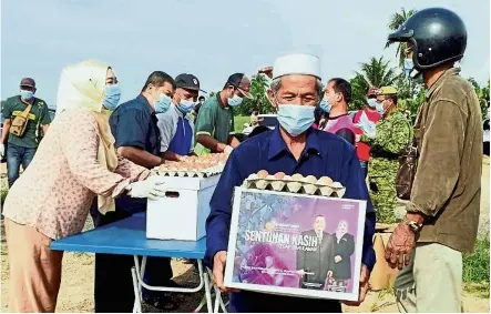  ??  ?? State rations: A man carrying a box of food courtesy of the Kedah government.