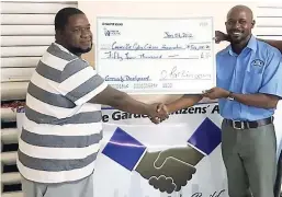  ?? CONTRIBUTE­D ?? CD Master (left) presents the cheque to Vladimir Wallace, president of the Cooreville Gardens Citizens Associatio­n.