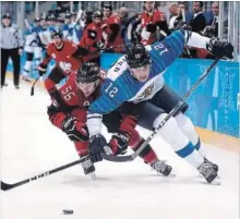  ?? RONALD MARTINEZ GETTY IMAGES ?? Maxim Noreau and Marko Anttila of Finland compete for the puck in Wednesday’s quarter-final. Noreau scored the only goal of the game.