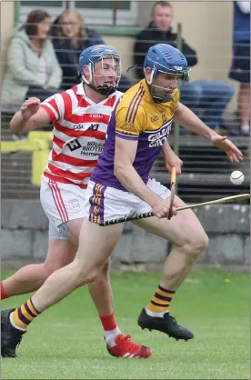  ??  ?? Michael Hanrahan (Faythe Harriers) under pressure from Ferns captain Ian Byrne.