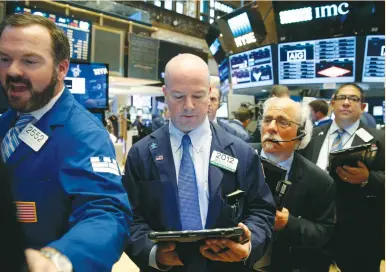  ?? (Brendan McDermid/Reuters) ?? TRADERS WORK on the floor of the New York Stock Exchange yesterday in New York City.