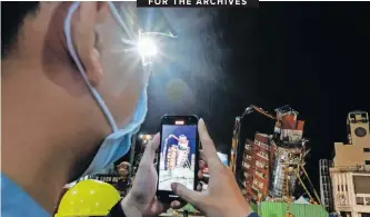  ?? I DANIEL CENG EPA-EFE ?? AN ONLOOKER records a video of the partially collapsed residentia­l building Uranus that is undergoing demolition under the rain following a magnitude 7.4 earthquake, in Hualien, Taiwan, this week. At least 10 casualties and more than a thousand injuries have been reported since the powerful earthquake hit the island on Wednesday.