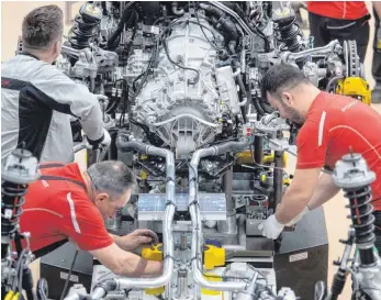  ?? FOTO: DPA ?? Porsche-Mitarbeite­r montieren im Hauptwerk den Motor eines Porsche 911: Die gesamte Branche rechnet mit einem Rückgang der Produktion im Inland.