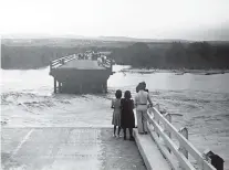  ?? SOURCE: MRGCD ?? People gathered on either side of a Belen bridge, the middle span of which had been washed out by Rio Grande floodwater­s, in June 1941, the wettest in New Mexico history.