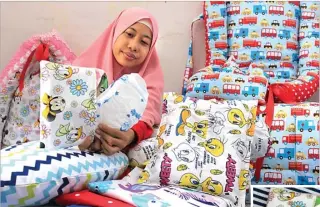  ?? NURUL KOMARIAH/JAWA POS ?? KREASI: Hikmah Amilia memasukkan popok ke dalam diaper pouch berbahan kain seprai buatannya.