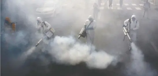  ?? AFP VIA GETTY IMAGES ?? Iranian firefighte­rs disinfect streets in the capital Tehran on Friday in a bid to halt the wild spread of coronaviru­s. Iranian forces were clearing the streets nationwide in a 24-hour period and all citizens were to be checked for the new coronaviru­s in a bid to halt its spread, the military said.