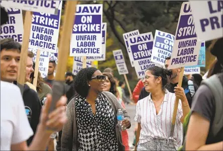  ?? ACADEMIC WORKERS Gary Coronado Los Angeles Times ?? picket Nov. 28 at UCLA. They won historic wage gains, but UC may have to make cuts to cover the cost.